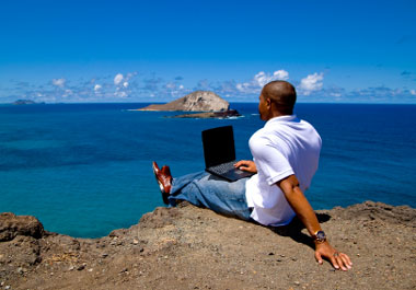 man by sea with laptop