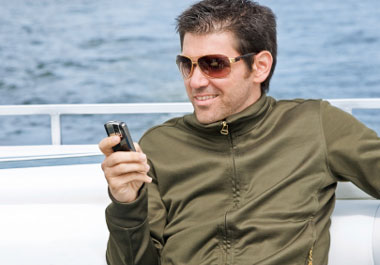 man on yacht with mobile